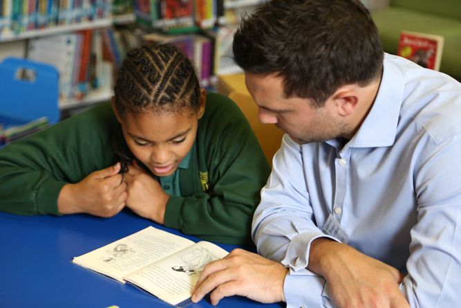 Boy being helped by a teacher at school