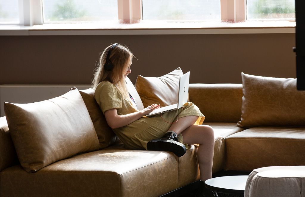 Lady sitting at laptop on a sofa