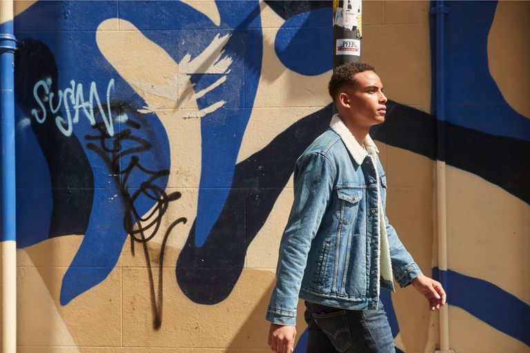 Man walking in front of a wall of art
