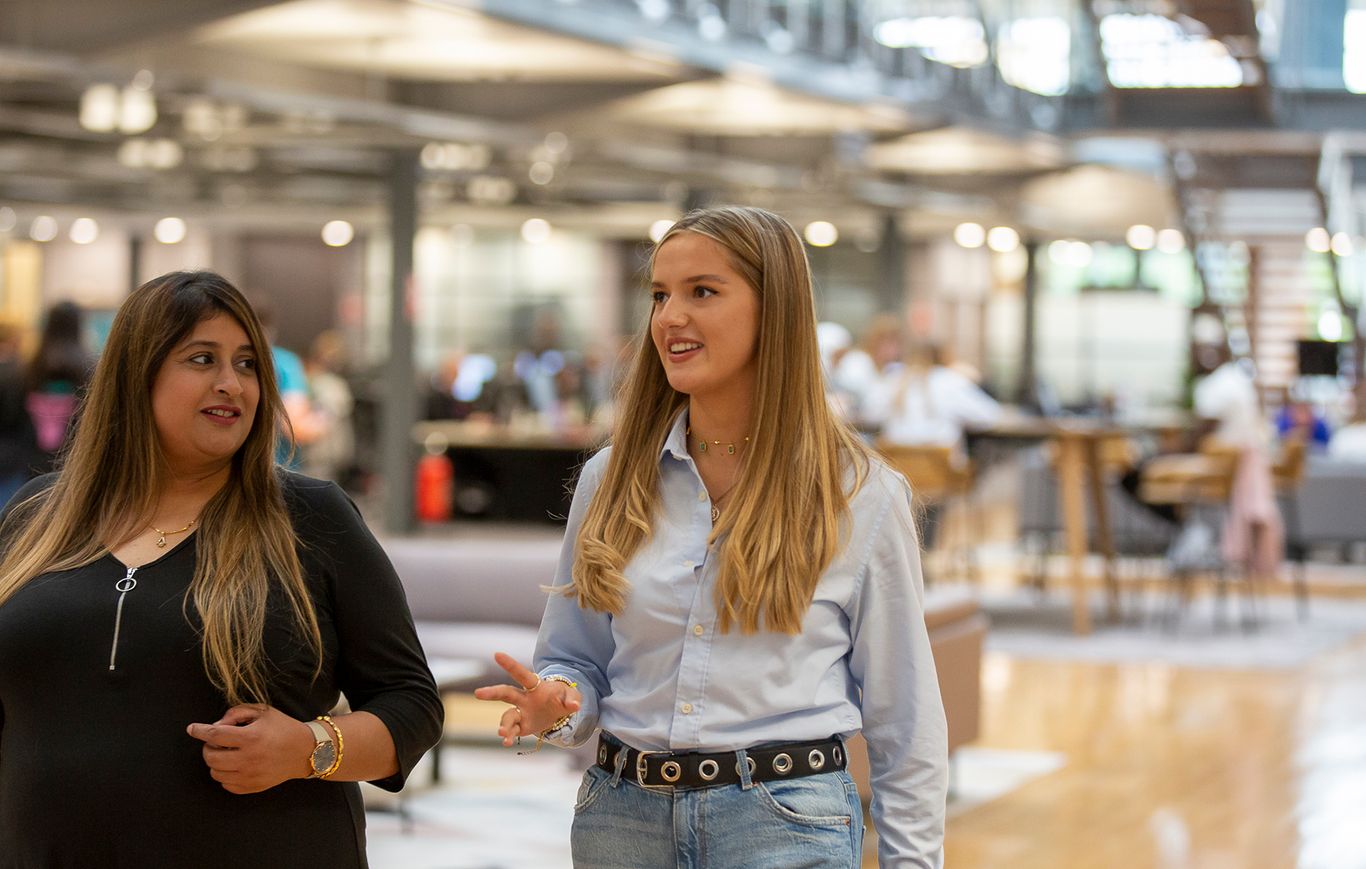 Female colleagues walking through office