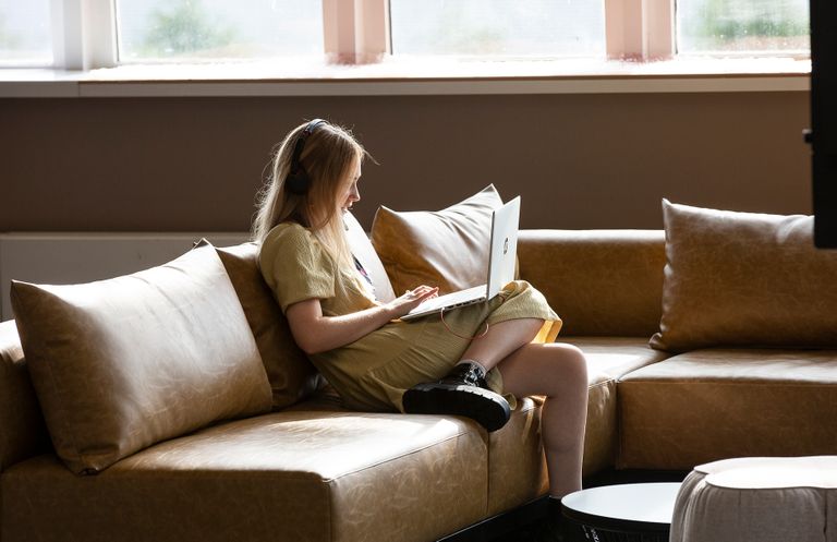Lady sitting at laptop on a sofa